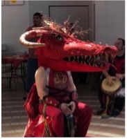individual seated wearing a Red Dragon Mask